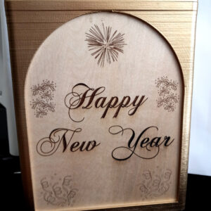 A rectangle box for holding bag-in-a-box wine bags. The box has gold trim and wooden panels engraved with the words "Happy New Year".