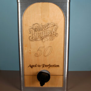 A custom wine box for bag-in-the-box wine bags. The box has a silver finish and an oak panel engraved with the words "Aged to Perfection" and the number 50.