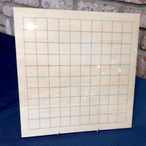 A laminated wooden square board with a grid, held up by a display stand.